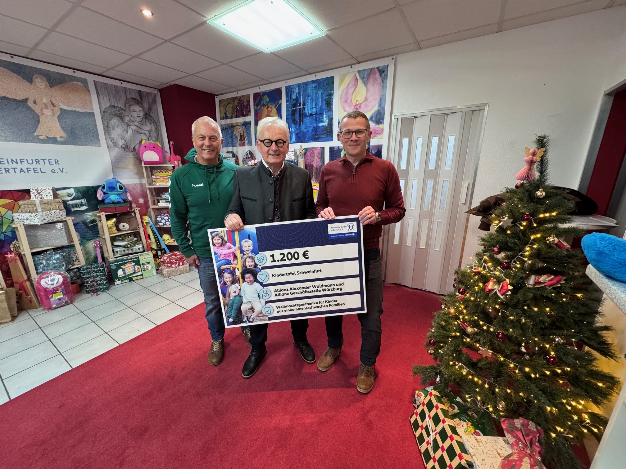 Foto. Irina Runde v.L. Rainer Zink (Stellvertr. Vorstand Kindertafel)  Stefan Labus (Vorsitzender Kindertafel)  Alexander Waldmann ( Allianz Hauptagentur)